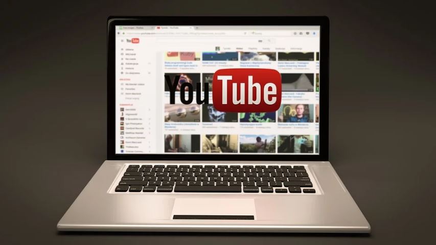Youtube Analytics: Imagem de um notebook com a tela aberta no YouTube e o logo do Youtube na frente