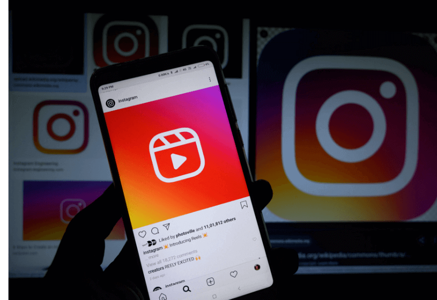 Instagram reels: imagem de uma mão segurando um celular com a tela mostrando um post reels do Instagram